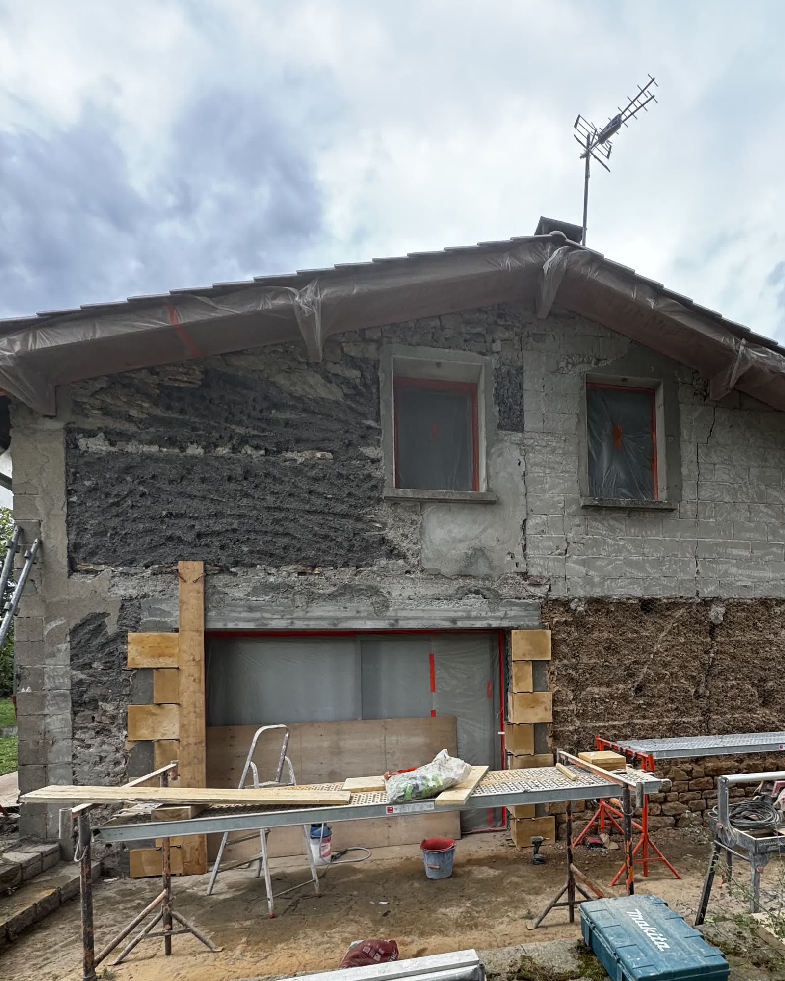 Pignon décroûté laissant voir le pisé, création d'une grande ouverture avec linteau — avant travaux