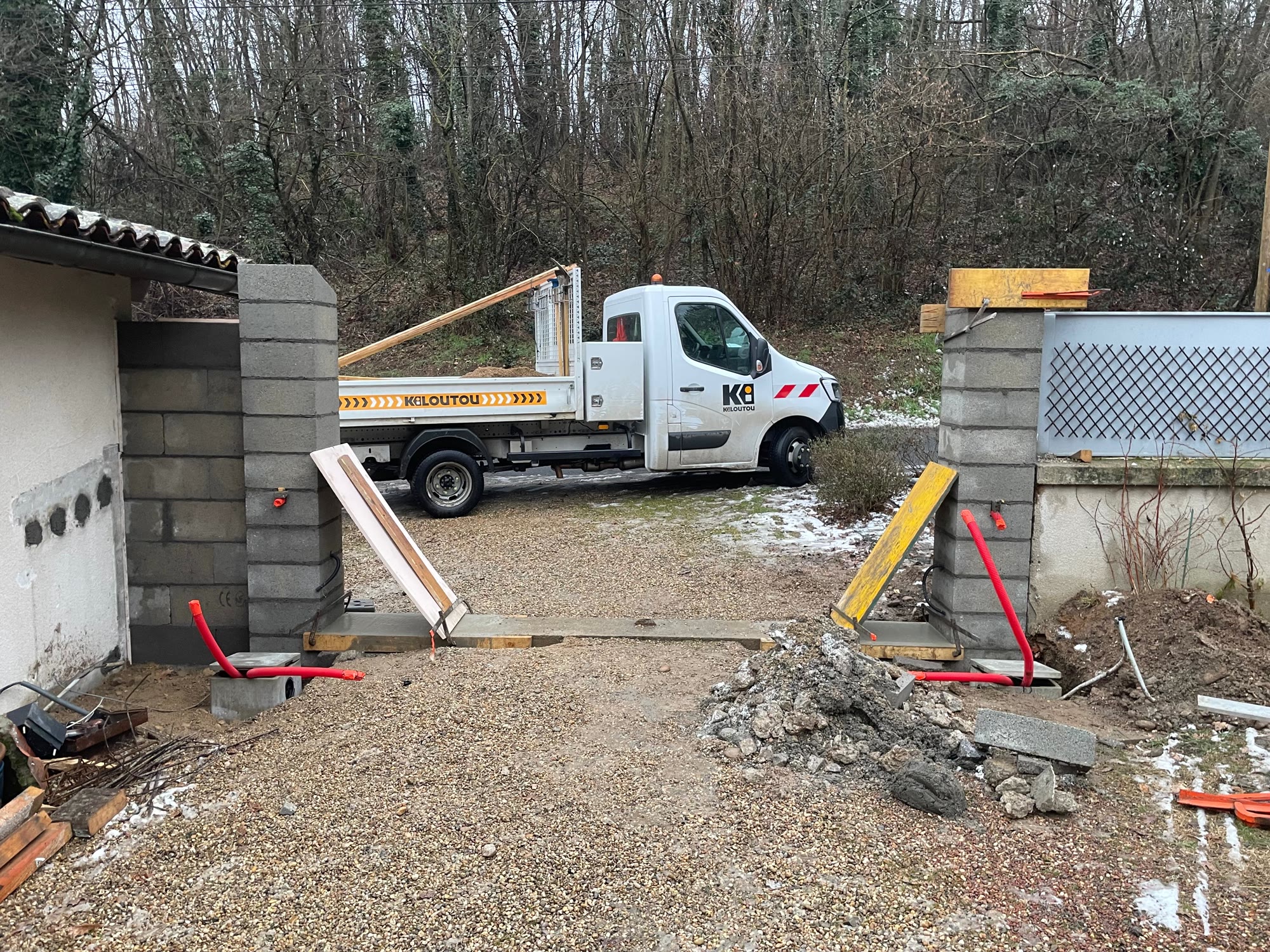 Entrée en travaux : piliers en parpaing bruts et accès ouvert — avant travaux