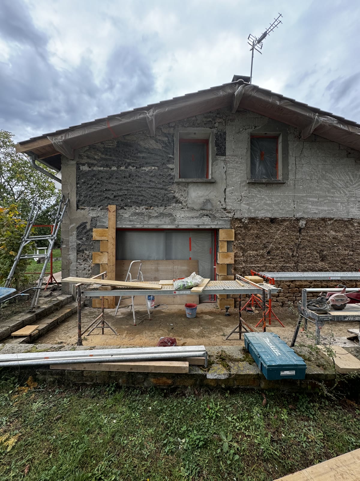 Façade en cours, enduit et pierre
