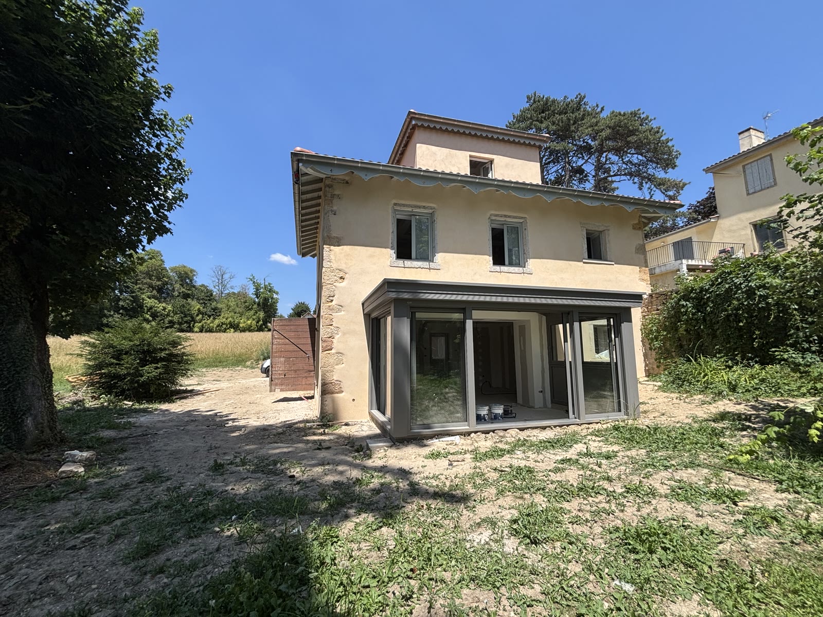 Extension vitrée et façade en pierre restaurée